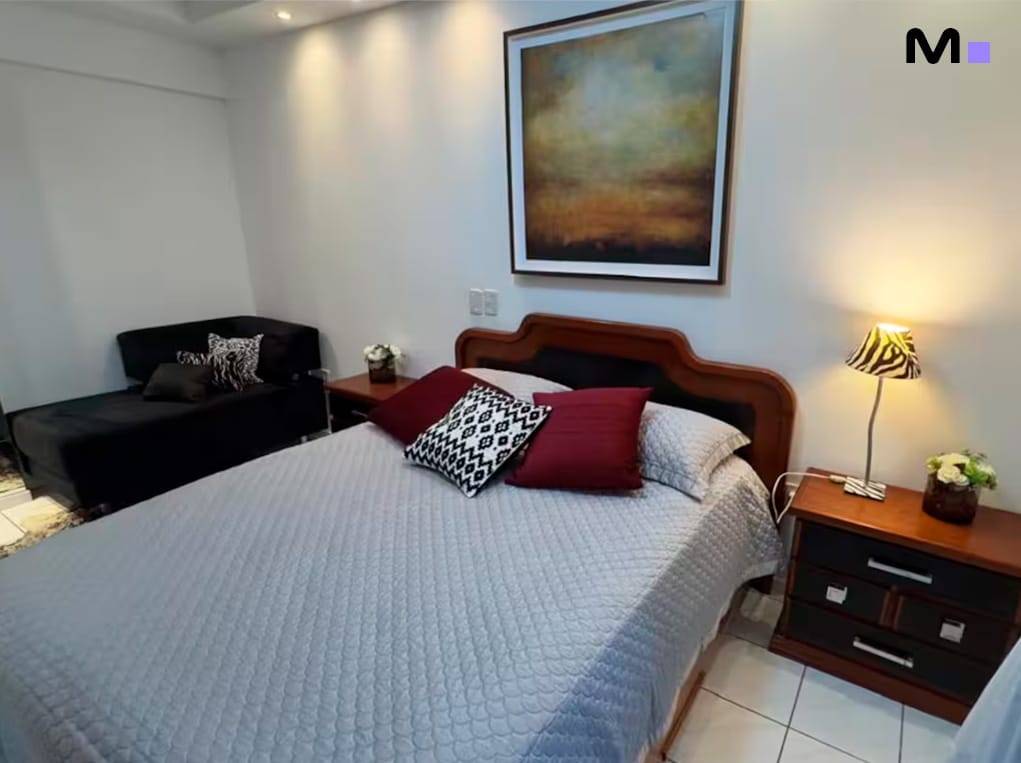 Quarto aconchegante no Residencial Oceânico com cama de casal, sofá e decoração moderna.