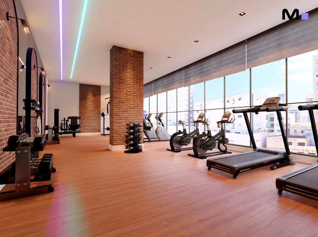 Academia moderna com equipamentos de ginástica e grandes janelas. Espaço amplo e bem iluminado.