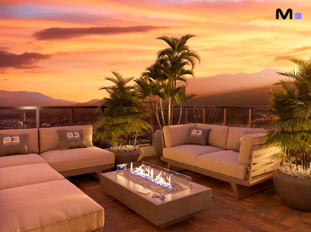 Terraço do Grand View Residence com lareira, sofás e vista panorâmica ao pôr do sol.
