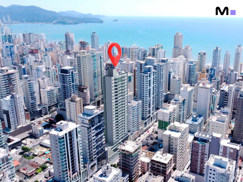 Vista aérea de Balneário Camboriú com um marcador de localização no topo de um prédio.