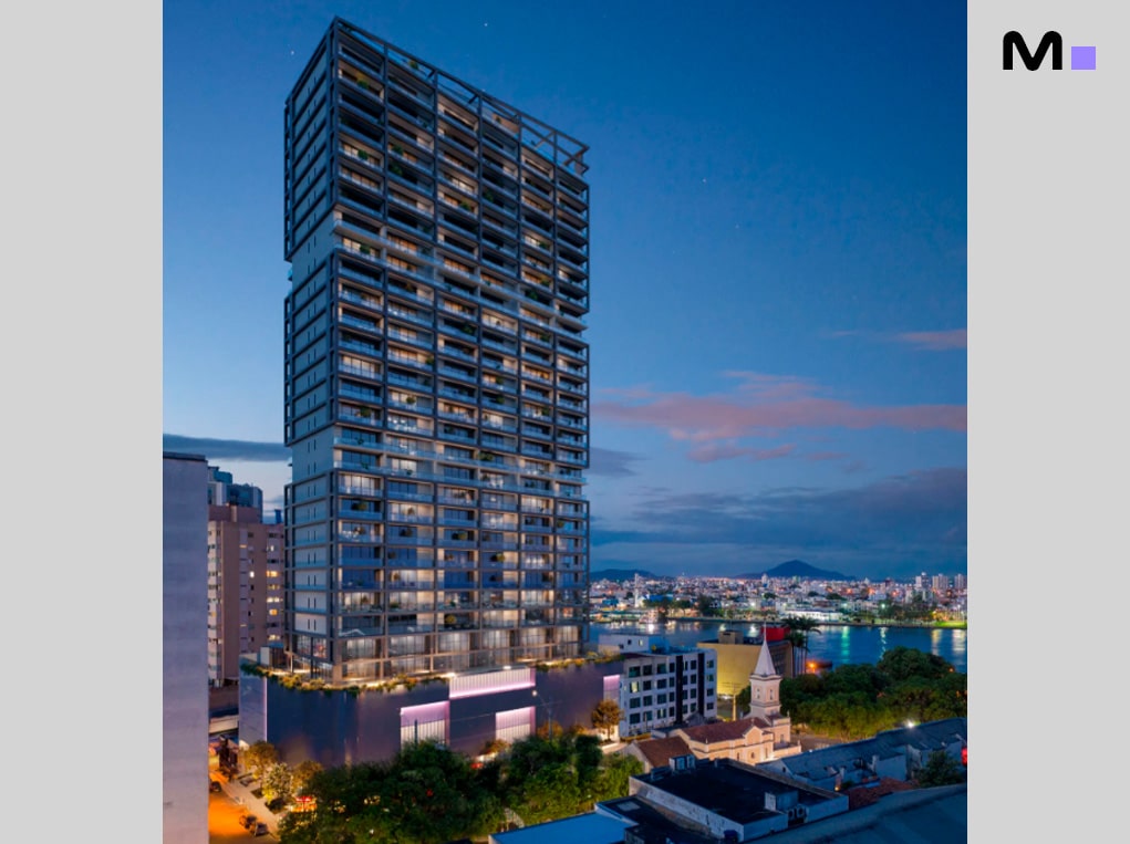 Edifício alto e moderno com vista para a cidade ao entardecer.