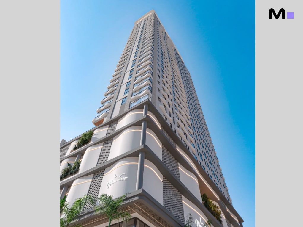 Vista de baixo de um arranha-céu moderno com varandas e céu azul.