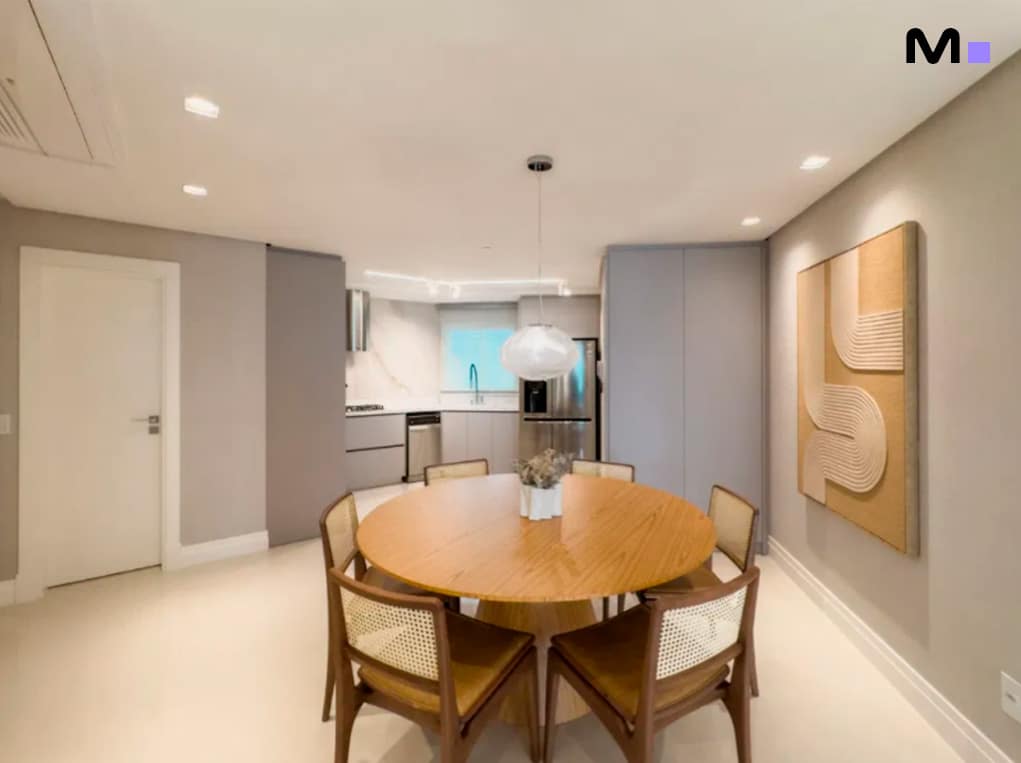 Sala de jantar moderna com mesa redonda de madeira e cadeiras de palha, parte do Infinity Coast Residence.