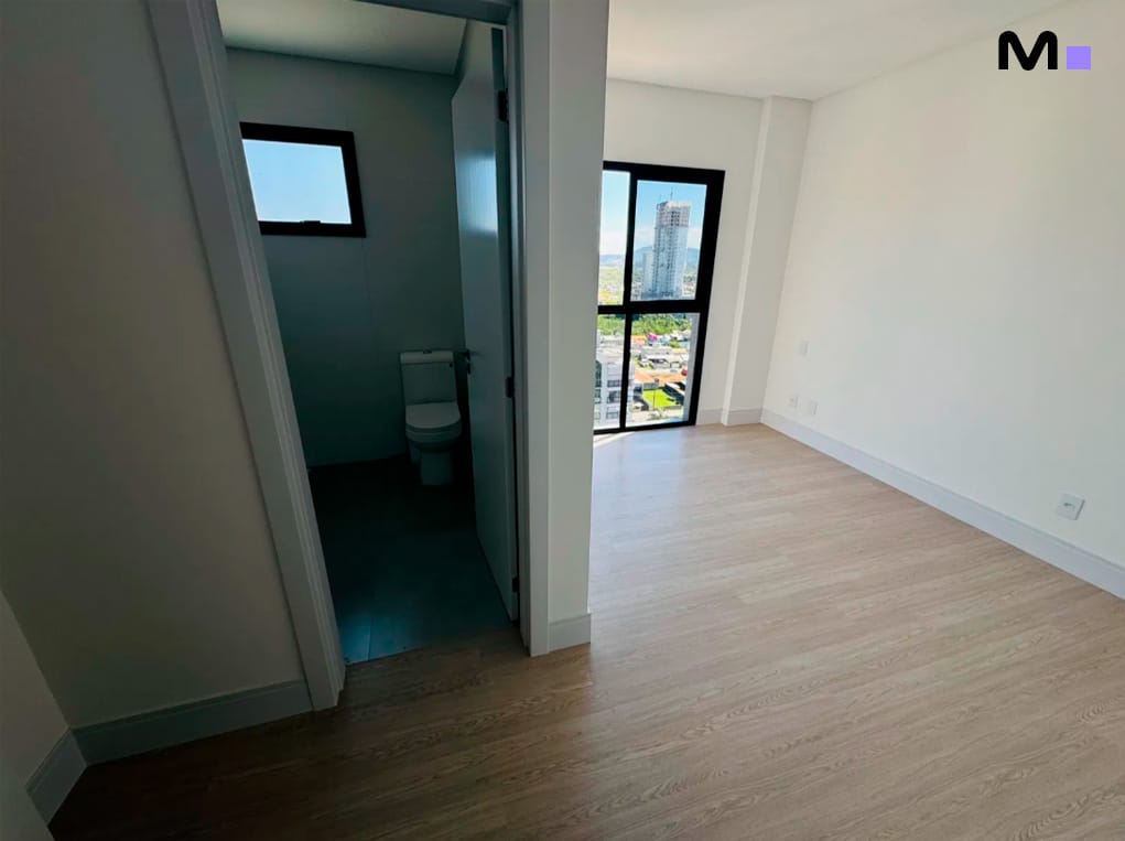 Interior do Edifício Ocean Cay: quarto claro com banheiro e vista da cidade.