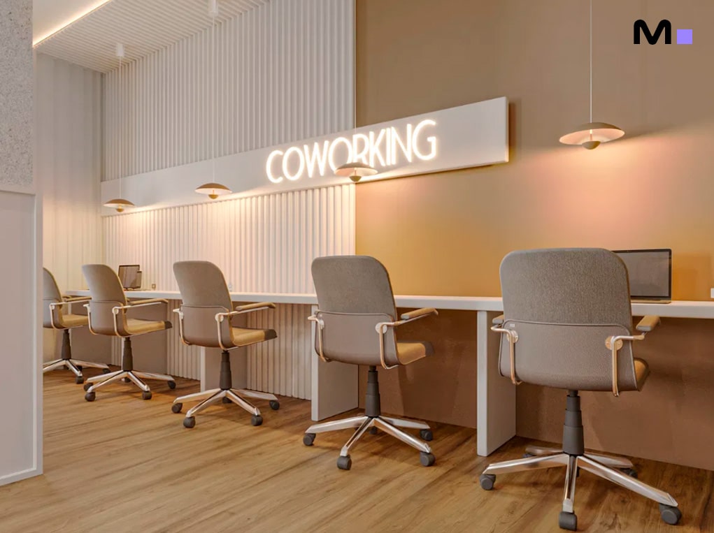 Espaço de coworking iluminado com cadeiras ergonômicas e a palavra "COWORKING" em destaque.