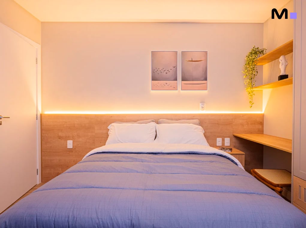 Quarto aconchegante do Edifício Leblon Residence com cama de casal, iluminação suave e decoração minimalista.