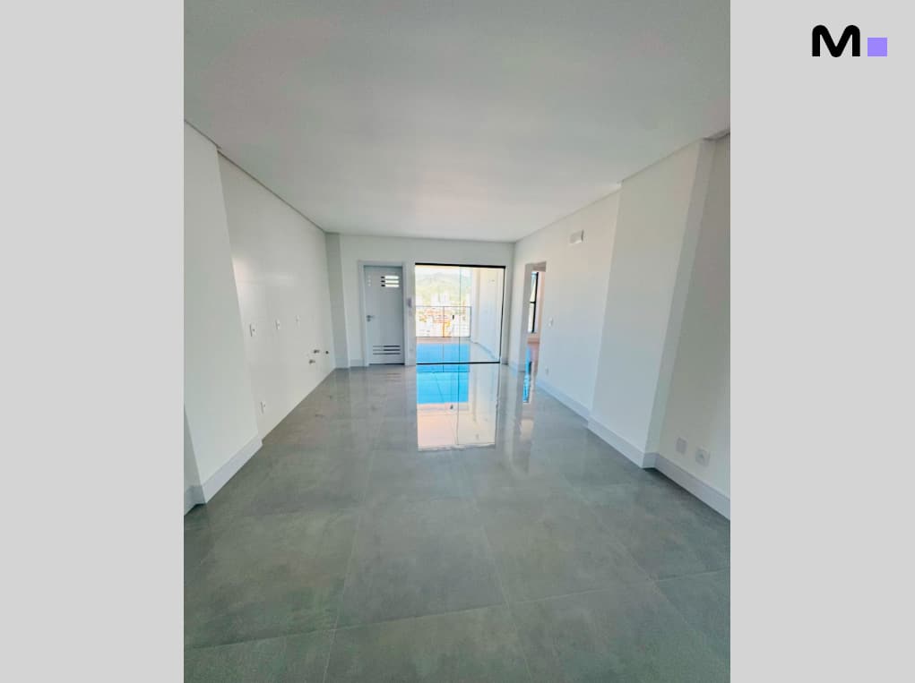 Interior claro e moderno do Edifício Ocean Cay, com piso cinza e vista para o exterior.