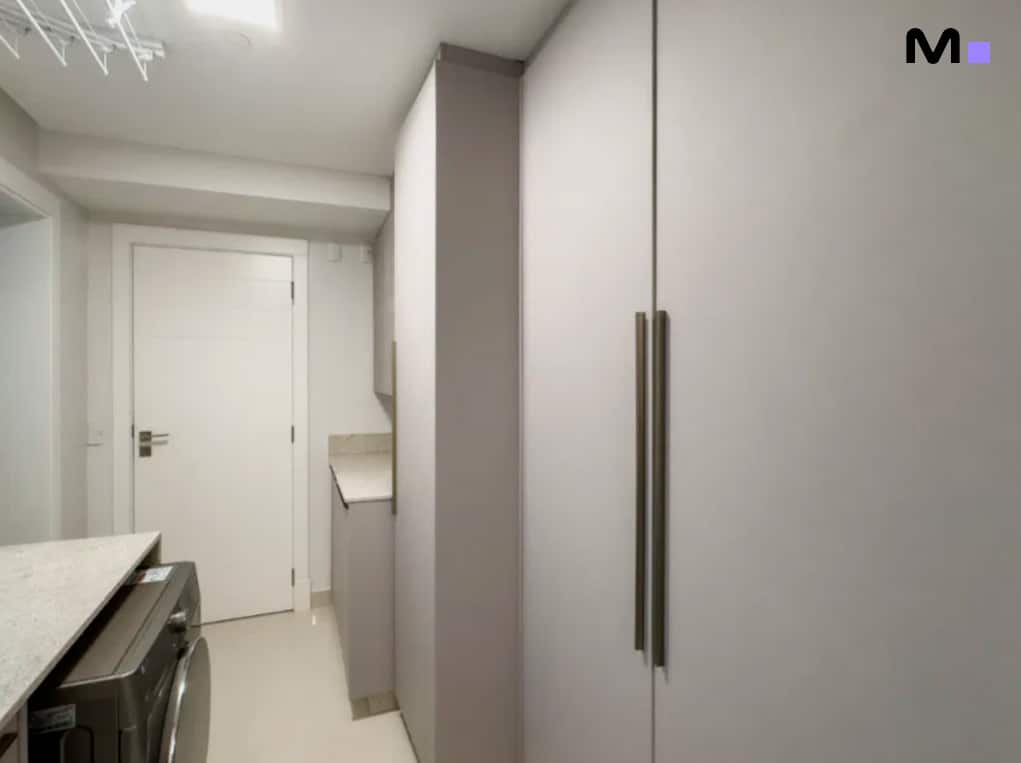 Lavanderia moderna com armários embutidos e máquina de lavar, parte do Infinity Coast Residence.