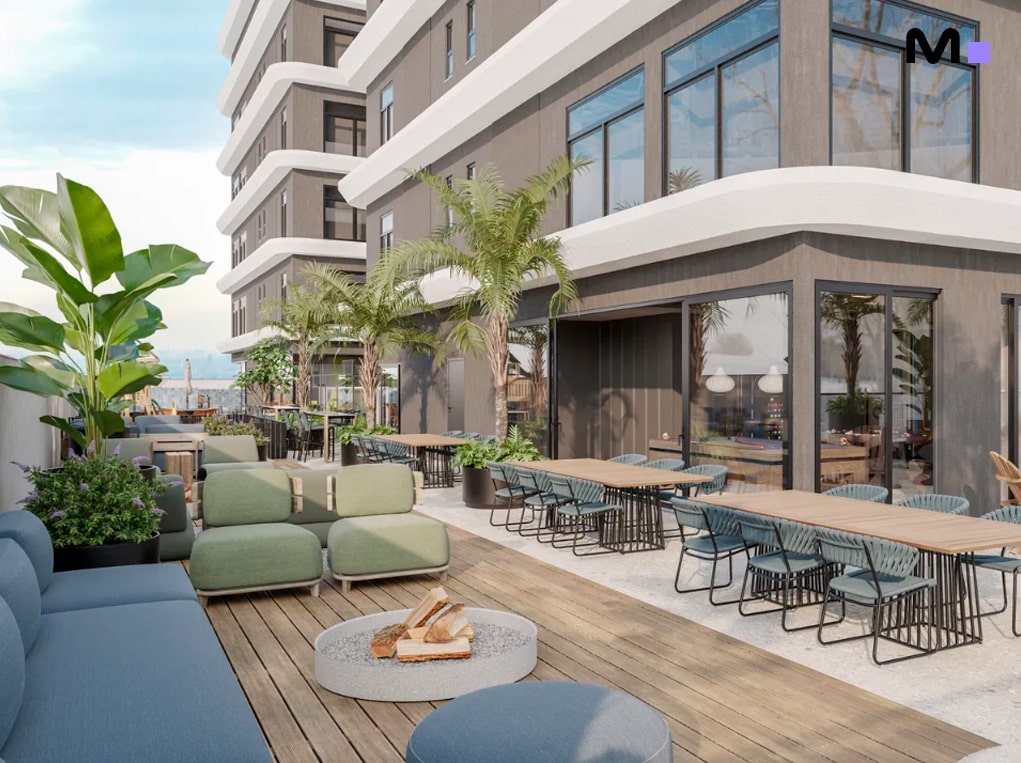 Terraço do Axion Towers com área de estar, mesas e paisagismo exuberante.