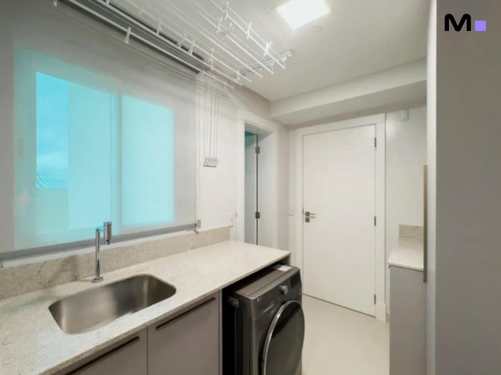 Lavanderia moderna com pia, máquina de lavar e varal de teto no Infinity Coast Residence.