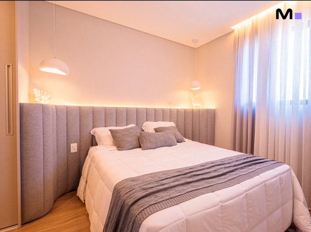 Quarto aconchegante no Edifício Leblon Residence com cama de casal, iluminação suave e decoração moderna.