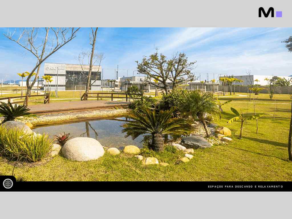 Lago tranquilo em parque empresarial ABC, com vegetação exuberante e edifícios ao fundo.