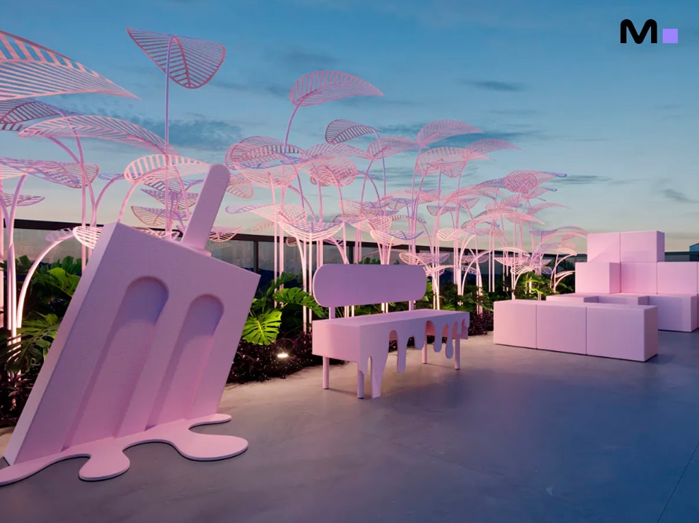 Espaço ao ar livre rosa com banco, escultura de picolé e plantas decorativas. Down Town by Housi.