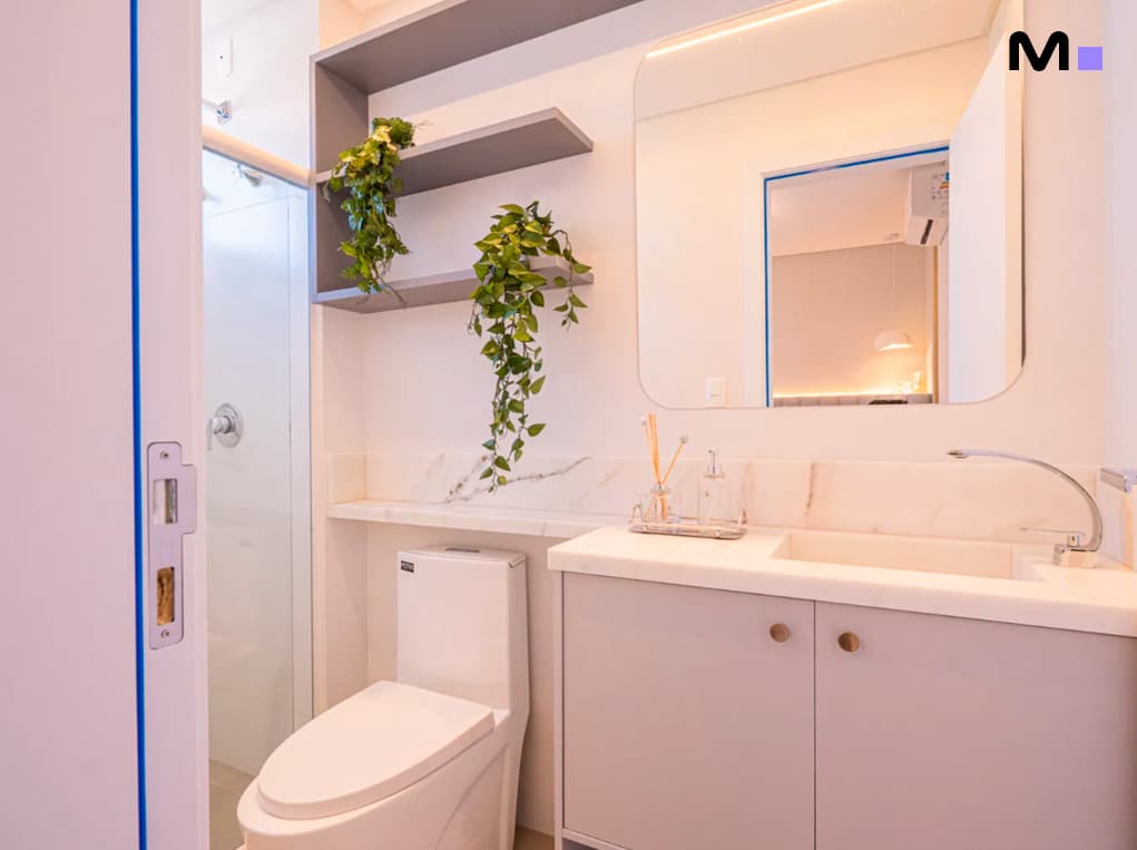 Banheiro moderno com vaso sanitário branco, pia e espelho no Edifício Leblon Residence.