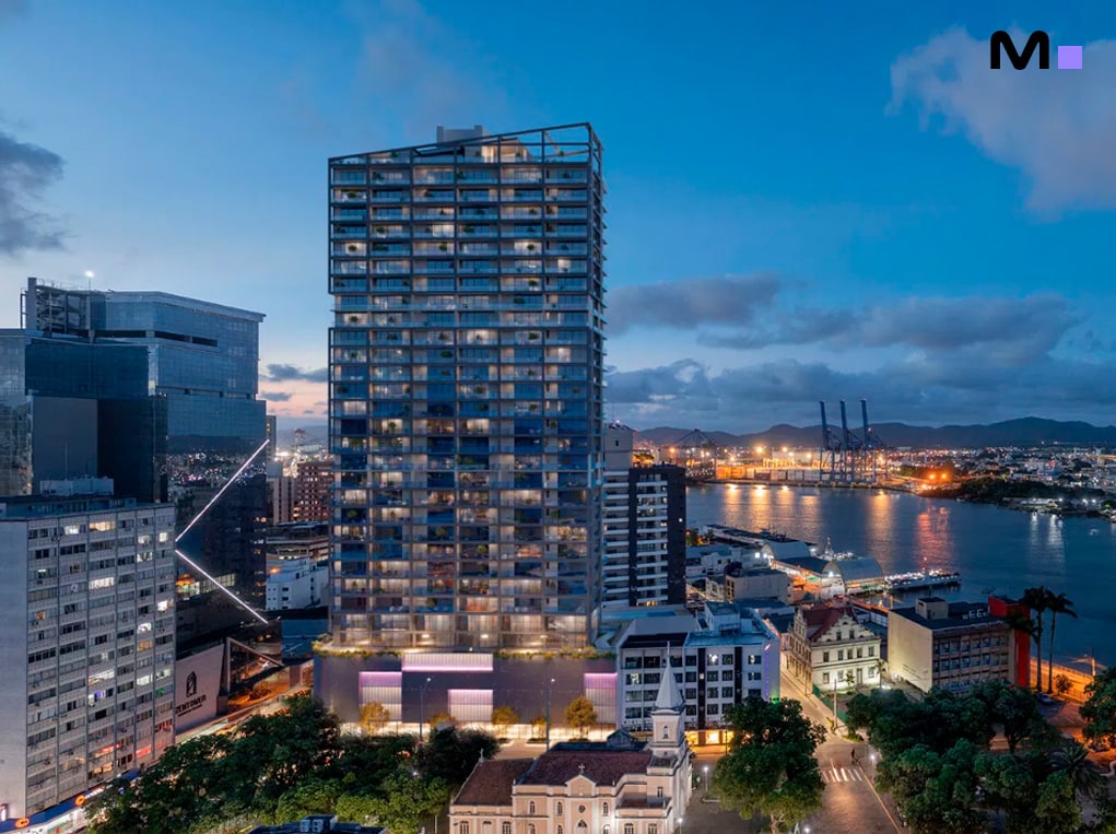 Edifício moderno em centro urbano à beira-mar, com vista para o porto. Arquitetura contemporânea.