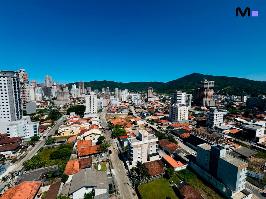 Vista aérea da cidade com o Edifício Ocean Cay ao fundo, sob céu azul.