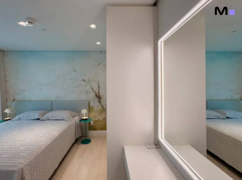 Quarto moderno com cama de casal e espelho, refletindo o design do Infinity Coast Residence.