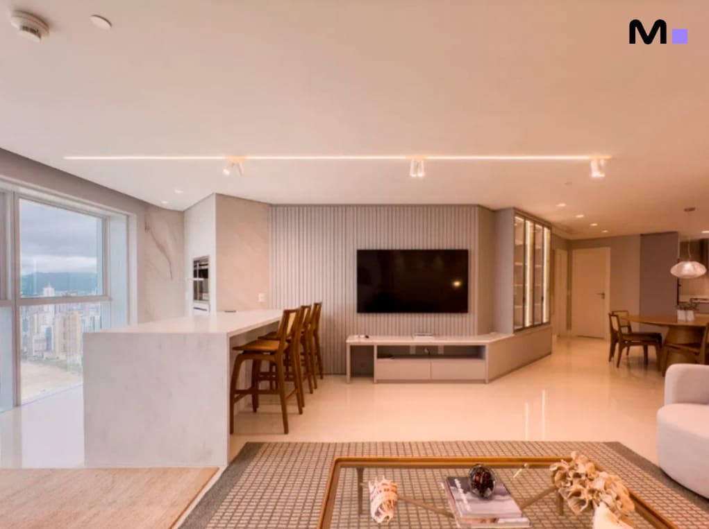 Interior moderno do Infinity Coast Residence com sala de estar, cozinha e vista da cidade.