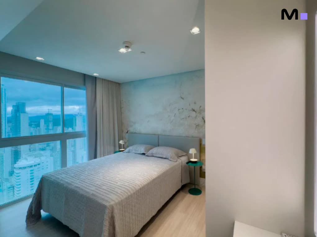 Quarto iluminado no Infinity Coast Residence com vista para a cidade.