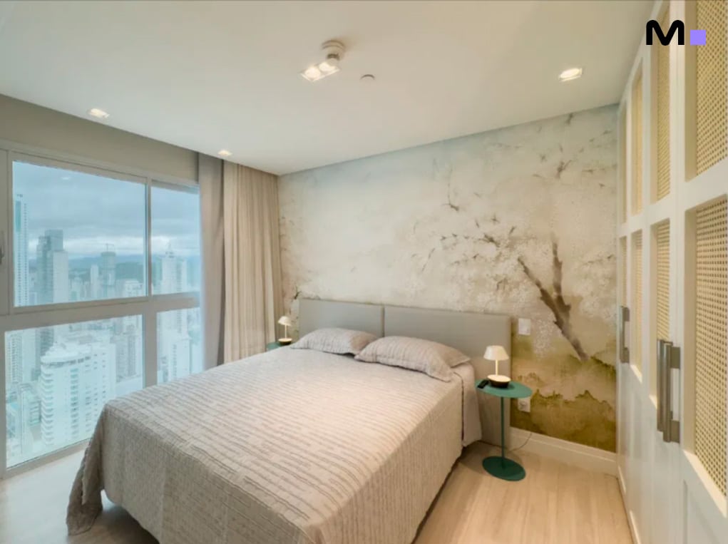 Quarto moderno com vista da Infinity Coast Residence, cama king size e decoração elegante.