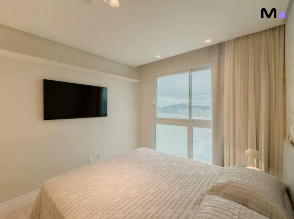 Quarto moderno com cama de casal e vista da Infinity Coast Residence.
