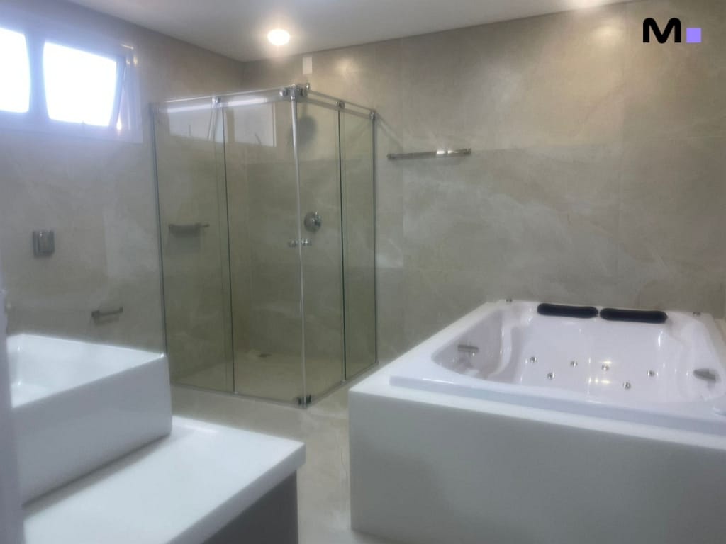 Banheiro moderno com box de vidro e banheira de hidromassagem. Condomínio House Haras.