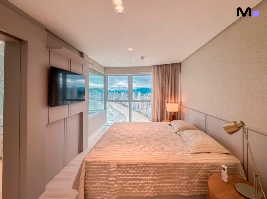 Quarto moderno com vista para a praia no Infinity Coast Residence. Cama de casal, TV e decoração elegante.