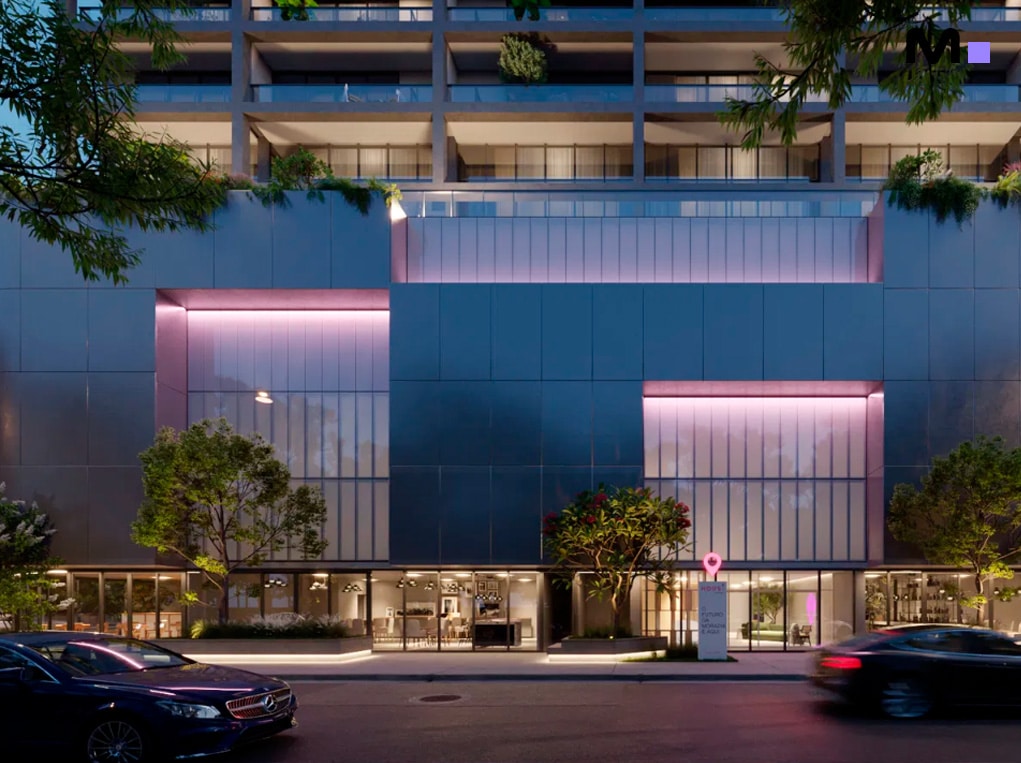 Fachada moderna do Down Town by Housi com carros na rua e iluminação rosa.