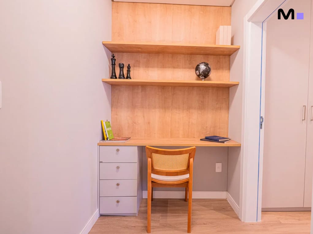 Escrivaninha de madeira clara com prateleiras e cadeira no Edifício Leblon Residence.