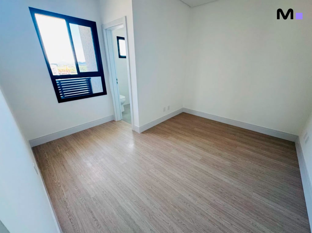 Quarto claro e arejado no Edifício Ocean Cay, com piso de madeira e janela ampla.