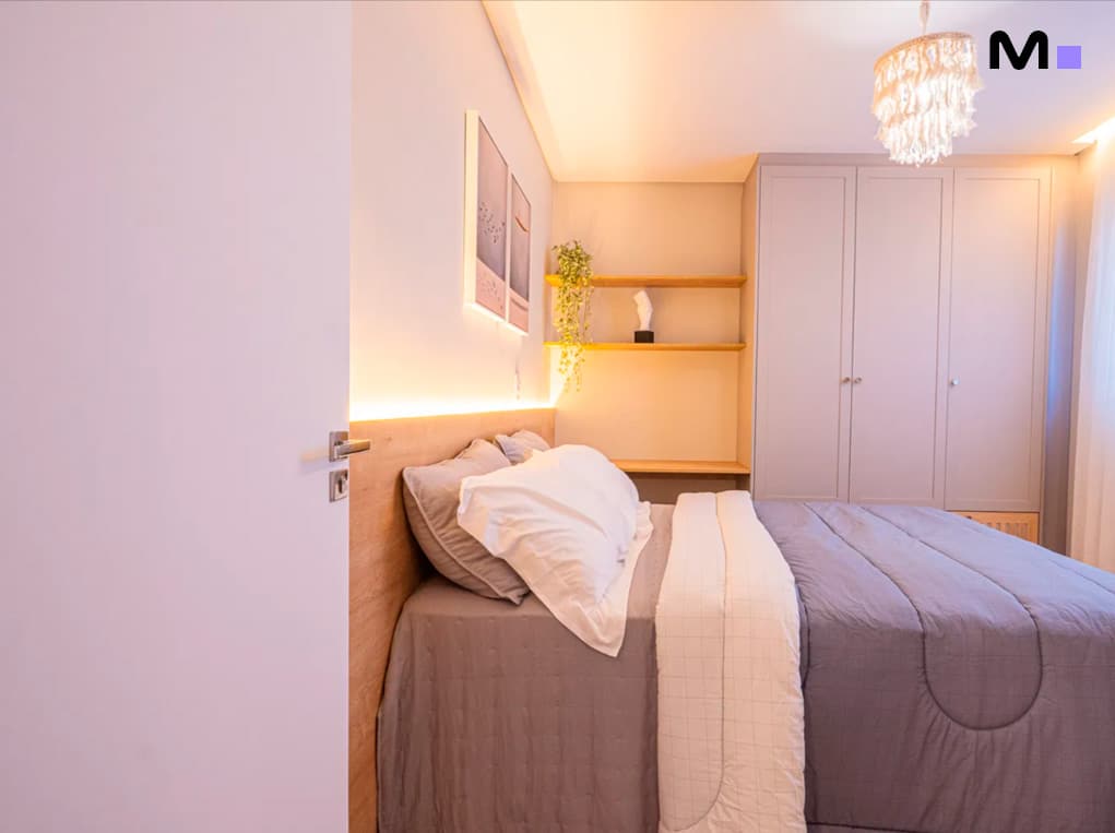 Quarto moderno do Edifício Leblon Residence com cama, armário e decoração aconchegante.