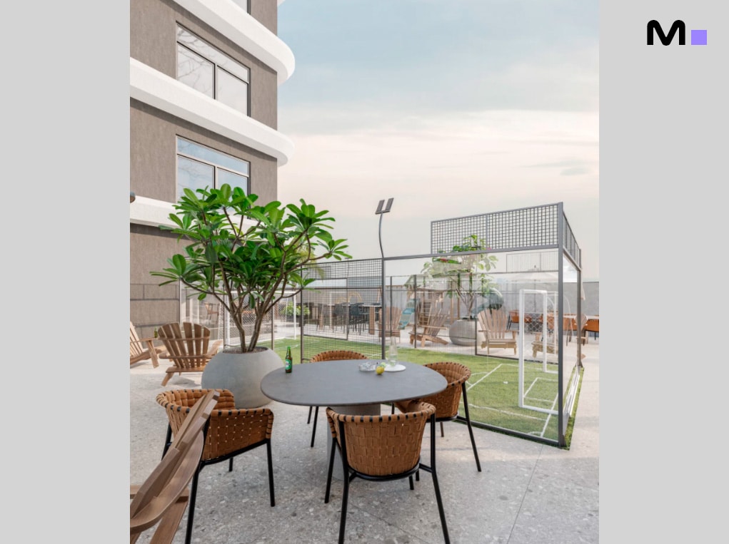 Área de lazer ao ar livre no Axion Towers: mesa, cadeiras e minicampo de futebol.