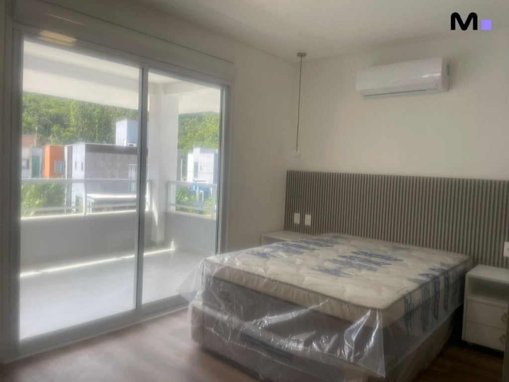 Quarto iluminado com cama king size e varanda no Condomínio House Haras.