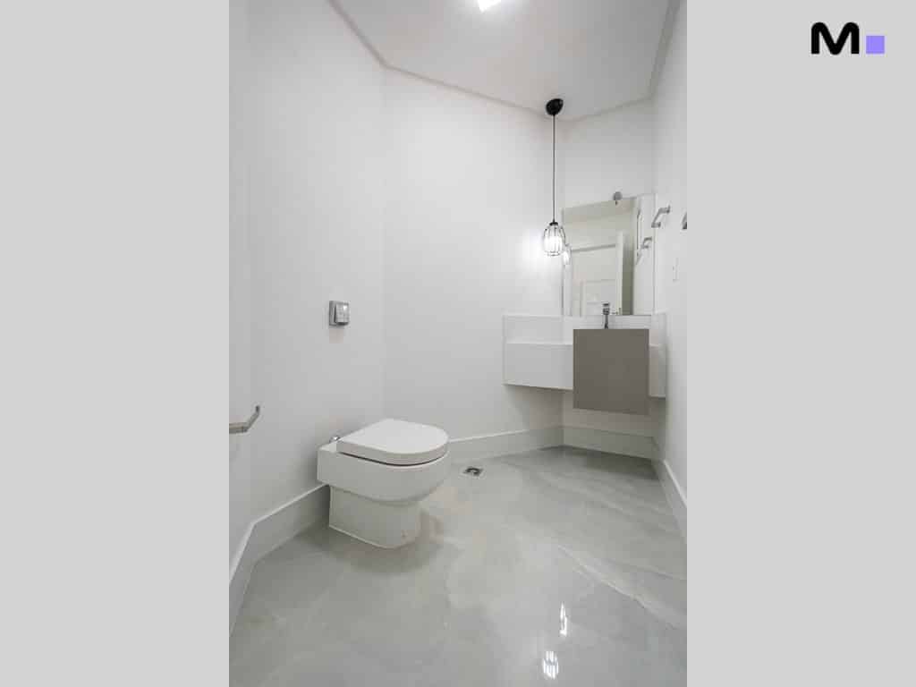 Banheiro moderno e minimalista no Condomínio House Haras, com vaso sanitário branco e pia elegante.