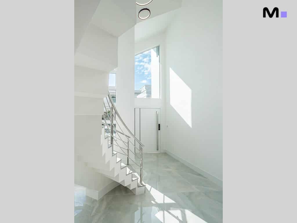 Escada moderna e luminosa em condomínio de casas.