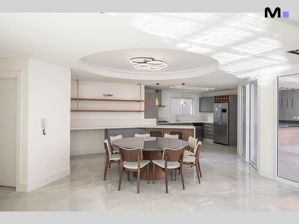 Sala de jantar moderna e espaçosa no Condomínio House Haras. Mesa redonda e cozinha integrada.