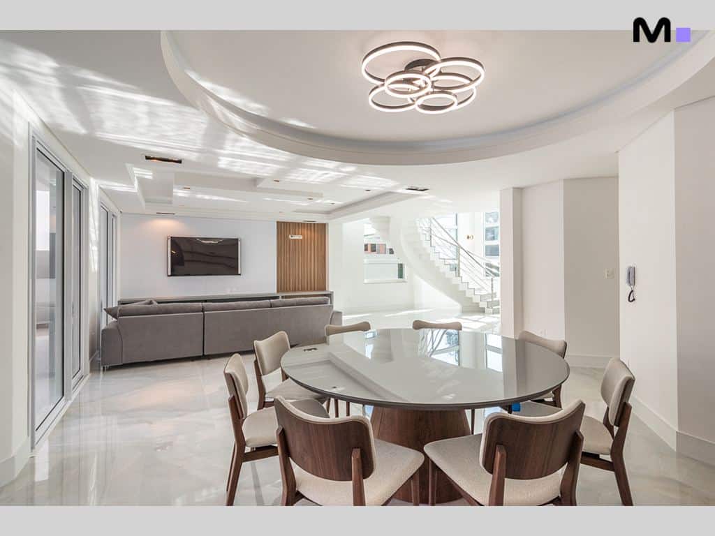 Sala de jantar moderna e iluminada no Condomínio House Haras. Mesa redonda e cadeiras elegantes.