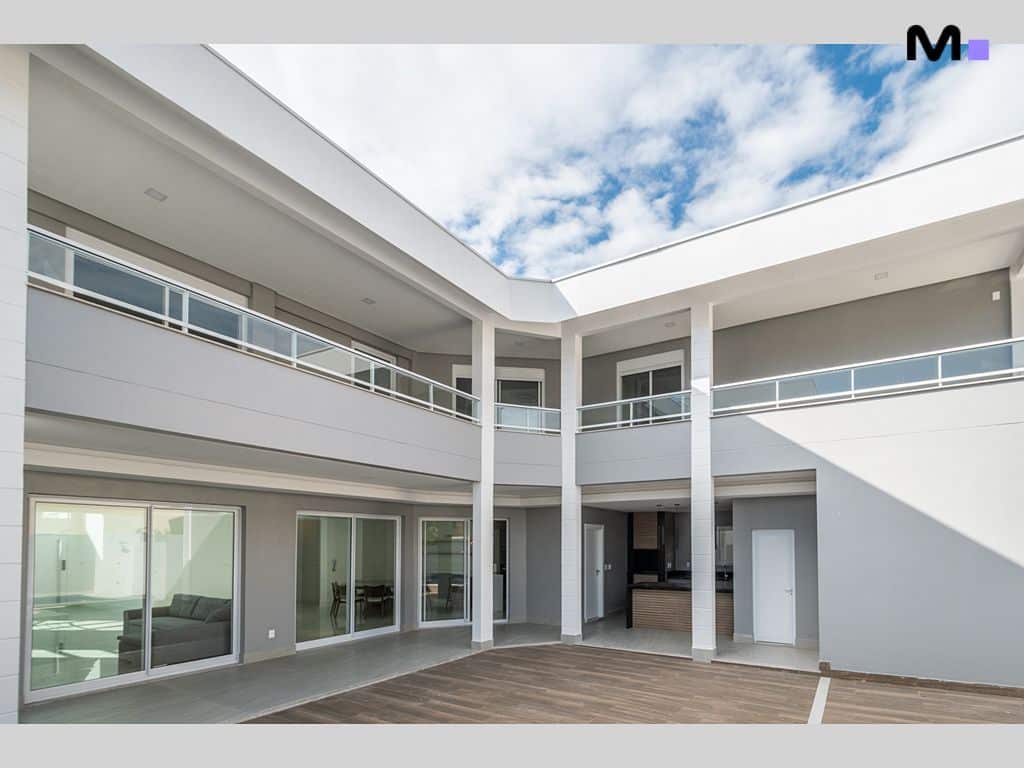 Pátio interno moderno do Condomínio House Haras com design elegante e iluminação natural.