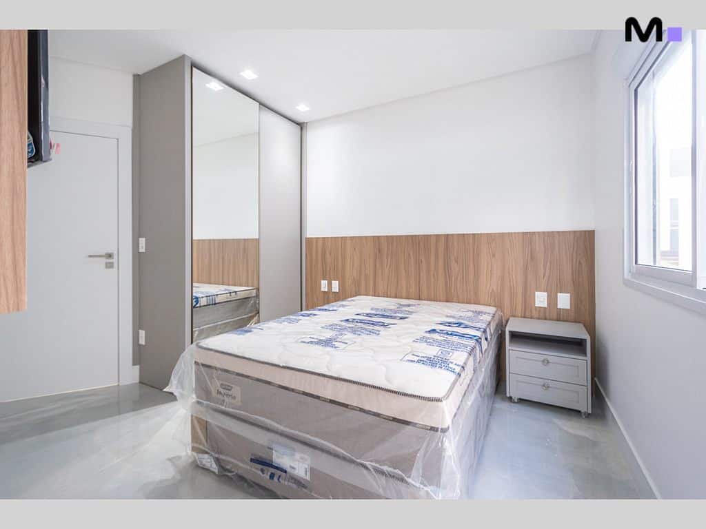 Quarto moderno com cama nova no Condomínio House Haras. Guarda-roupa espelhado e piso brilhante.