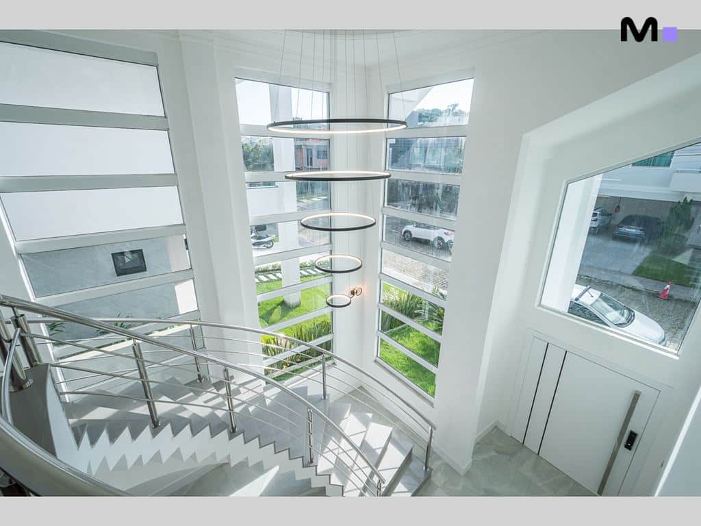 Escada moderna e luminosa em Condomínio House Haras, com janelas amplas e design elegante.