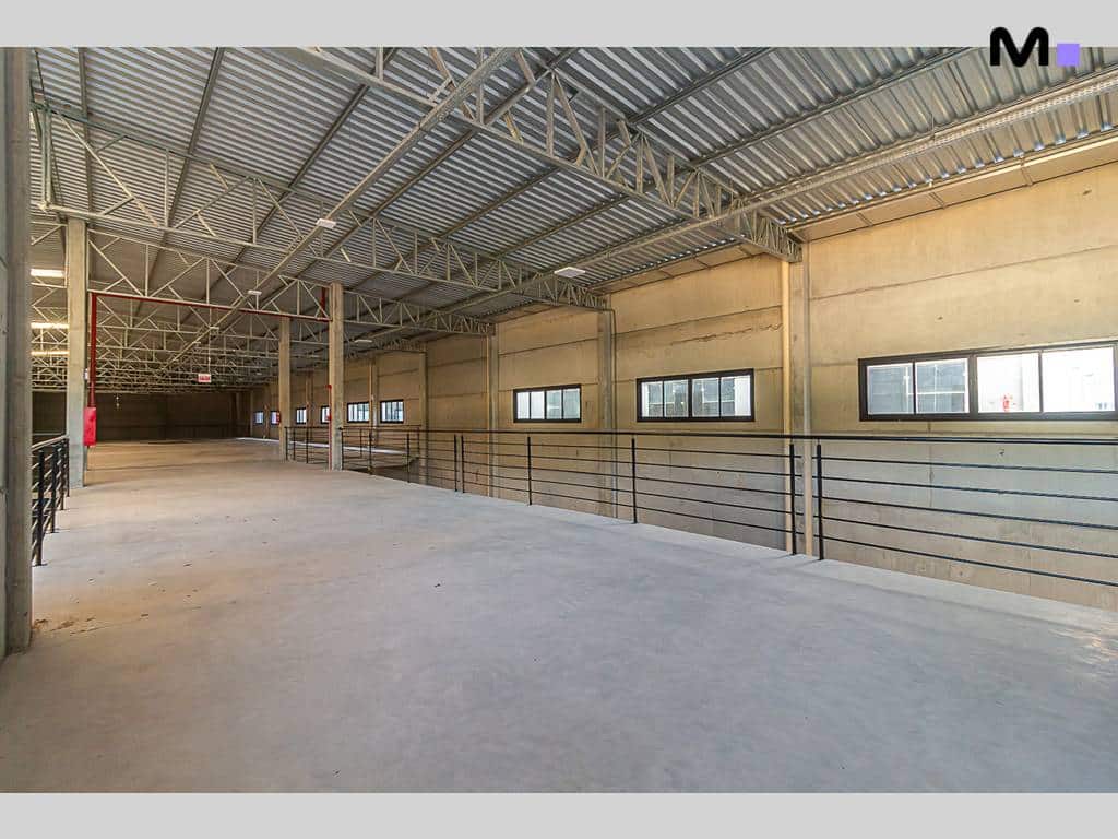 Interior do ABC Business Park: Espaço amplo com estrutura metálica e janelas.