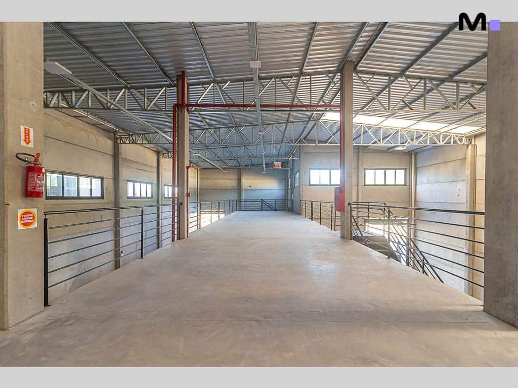 Interior do ABC Business Park: plataforma de concreto com extintor e janelas.