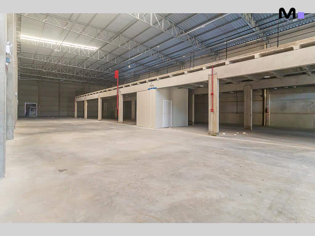 Interior amplo de armazém no ABC Business Park com estrutura metálica e piso de concreto.