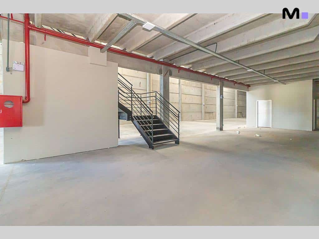 Interior de armazém com escadas metálicas e sistema de incêndio vermelho. ABC Business Park.