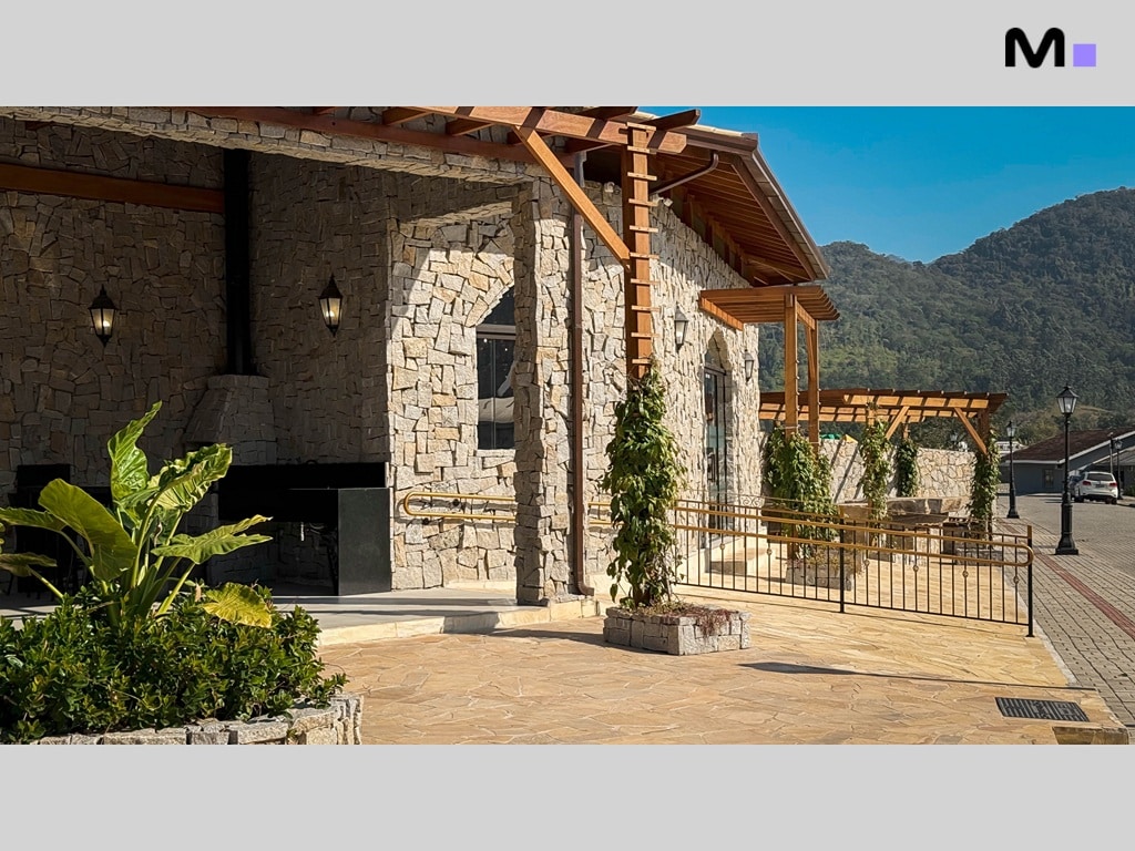 Condomínio Vale das Pedras: Fachada rústica com churrasqueira e área de lazer externa.