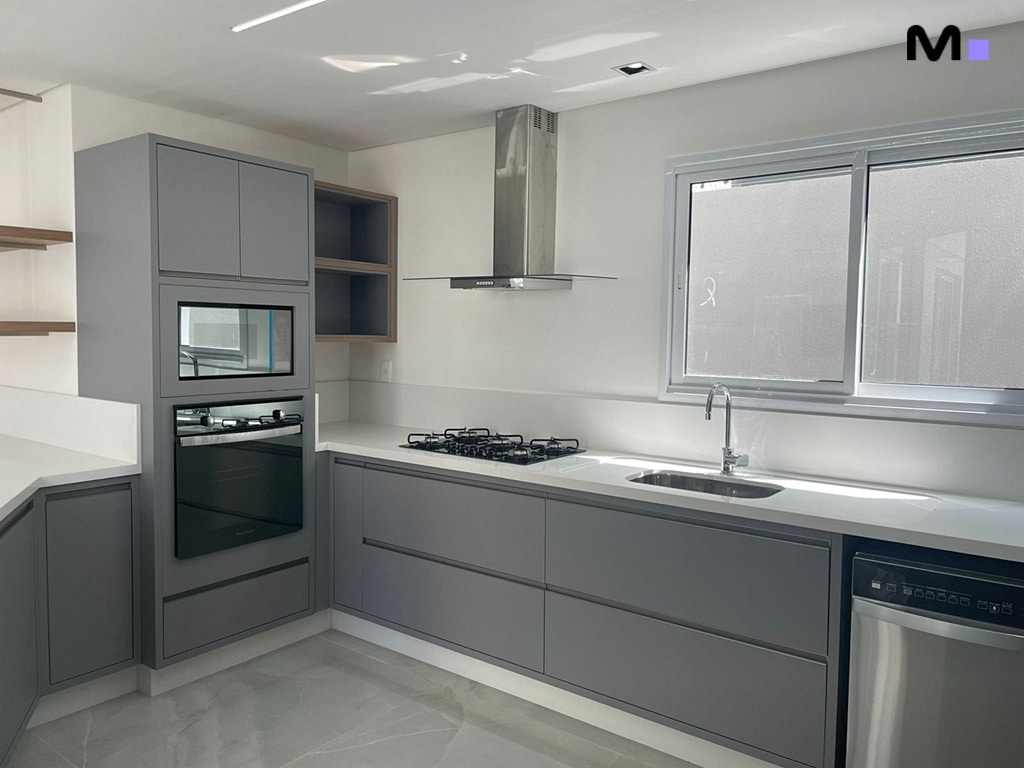 Cozinha moderna em tons de cinza com armários planejados e bancada clara. Condomínio House Haras.