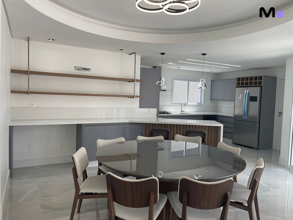 Cozinha moderna e elegante com mesa de jantar redonda e iluminação sofisticada.