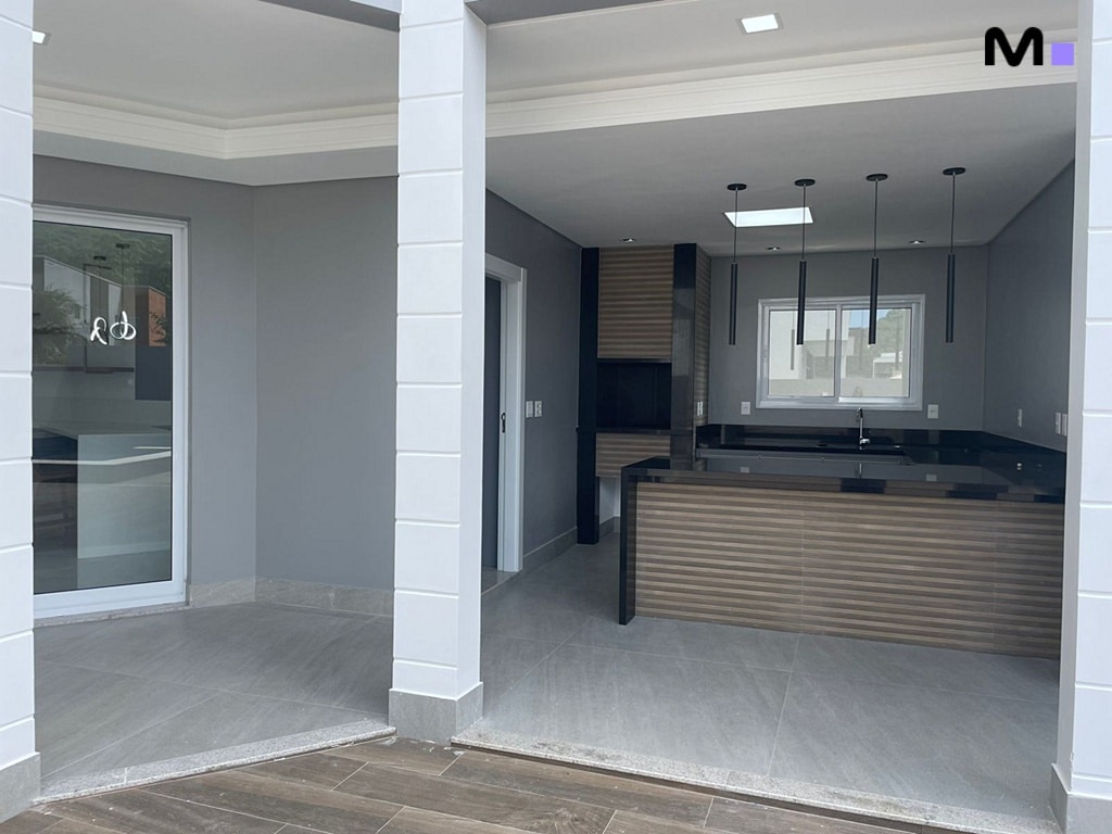 Cozinha moderna e elegante no Condomínio House Haras, com iluminação suspensa e bancada escura.