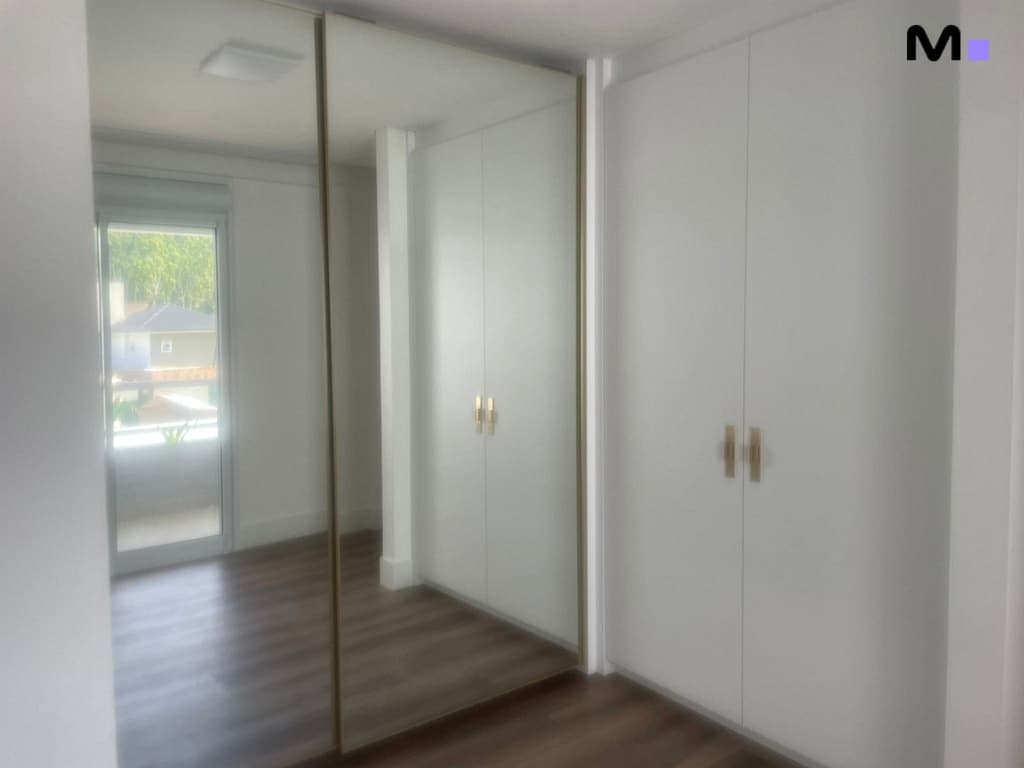 Armário branco em quarto moderno com espelho. Condomínio House Haras.