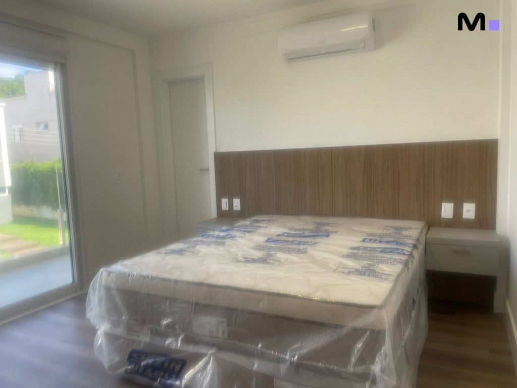 Quarto moderno com cama king size e cabeceira de madeira no Condomínio House Haras.